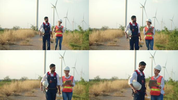 两个技术人员在风电场边走边聊