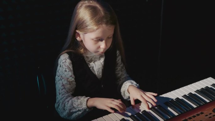 孩子在电子钢琴上弹奏简单的旋律