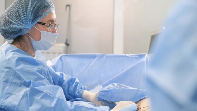 一组外科医生在手术中使用外科腹腔镜器械切除腿部静脉