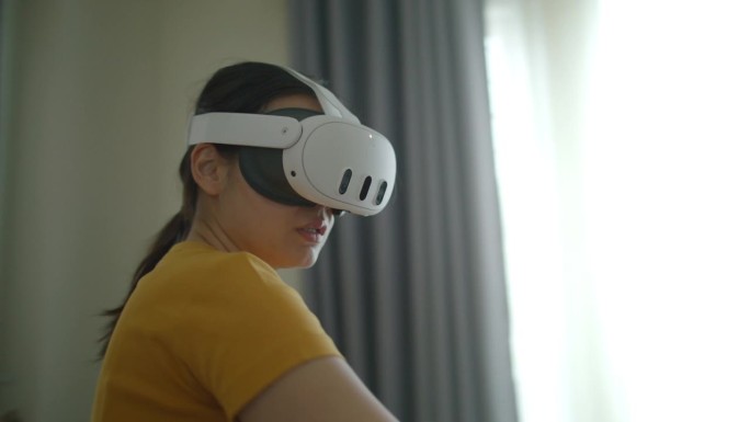 戴着虚拟现实耳机或虚拟现实眼镜的年轻女性