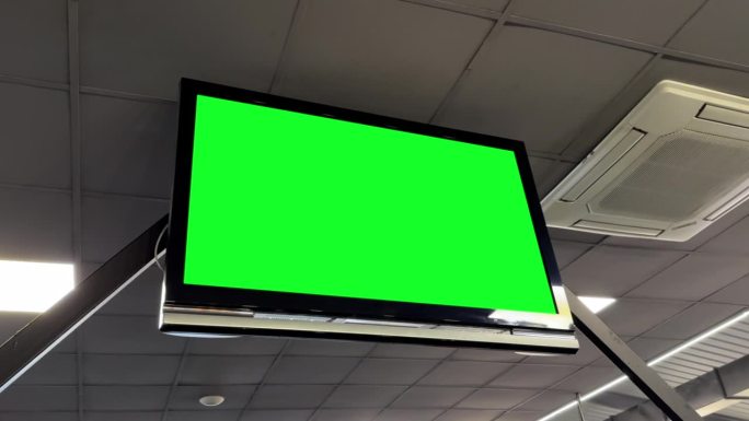 平板电视上的Chromakey绿色屏幕，安装在健身房的天花板上，用于动态内容显示。