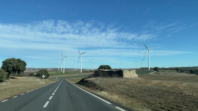 大规模风力涡轮机的可持续能源线，从汽车上主观参观。生态转型概念可再生能源气候变化绿色能源。