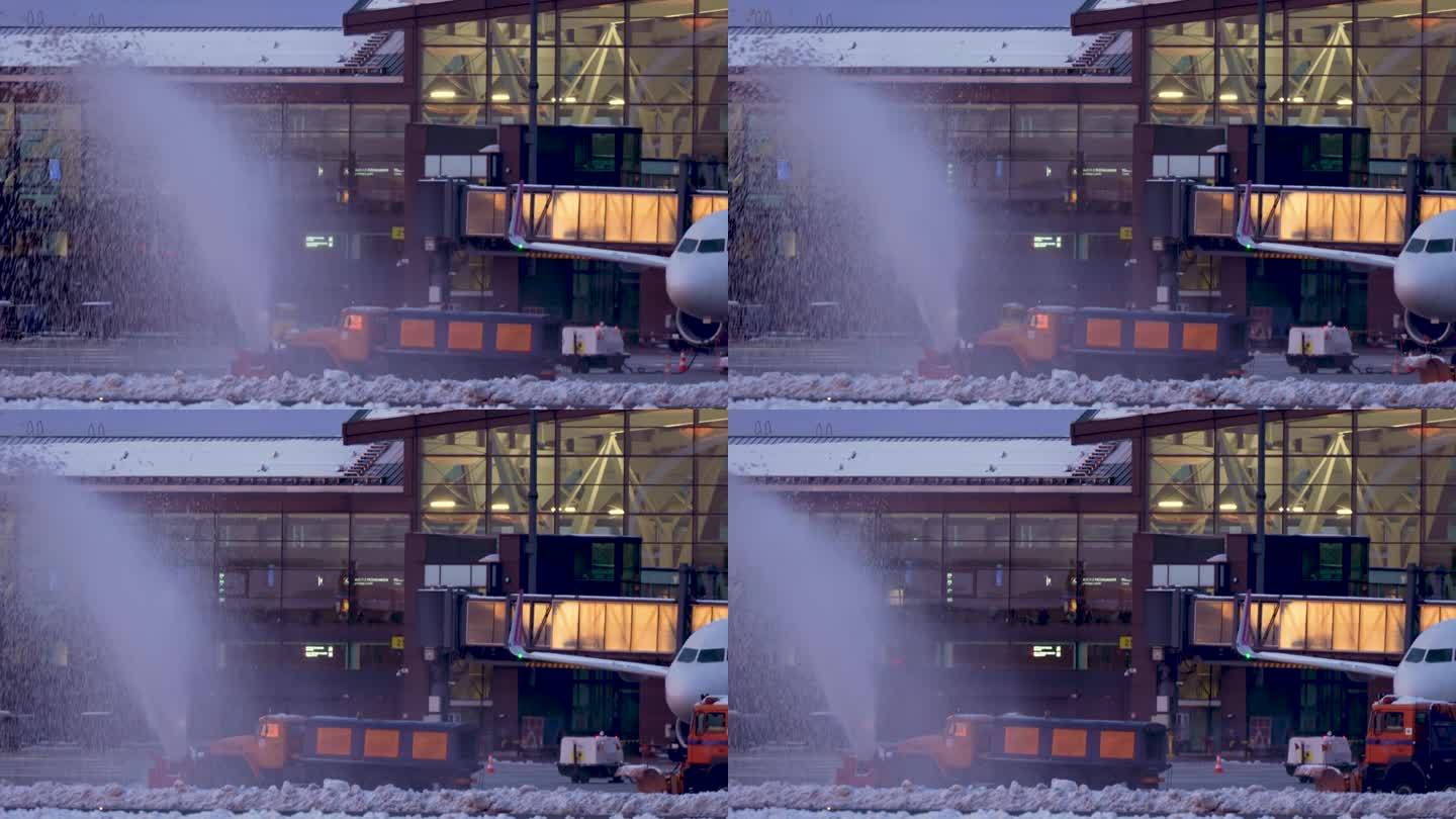 大型橙色扫雪车正在清理国际机场航站楼和跑道上的冷雪，北极地区出现严重外流和暴风雪。慢镜头