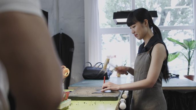 一位日本女工匠用锤子塑造皮革