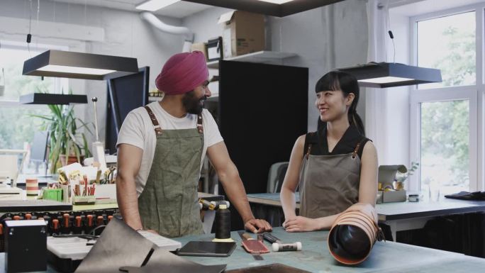 日本和印度的同事在他们的皮革工作室里友好地聊天