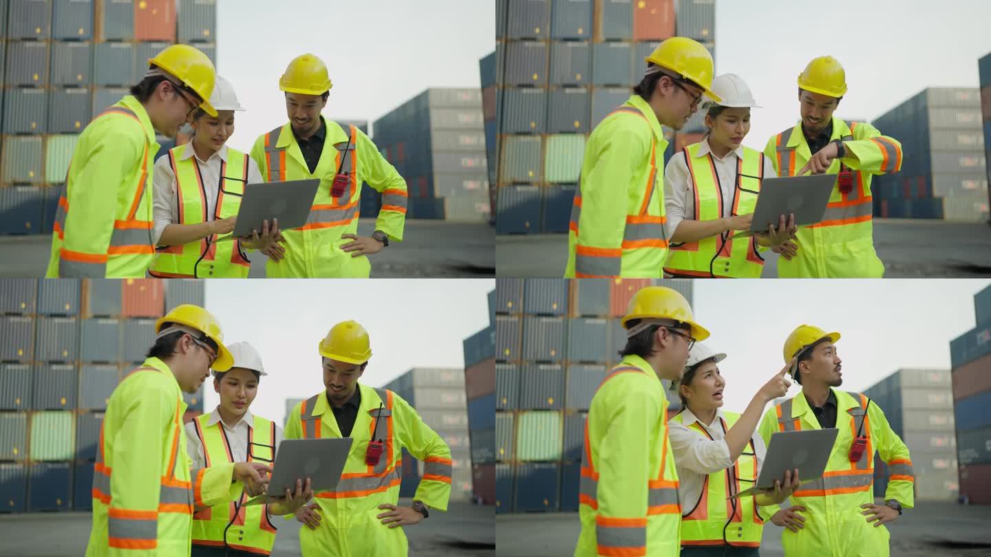 一组工业工程师，身穿安全制服，头戴头盔，手持笔记本电脑在集装箱码头工作。货物运输进出口业。物流航运堆