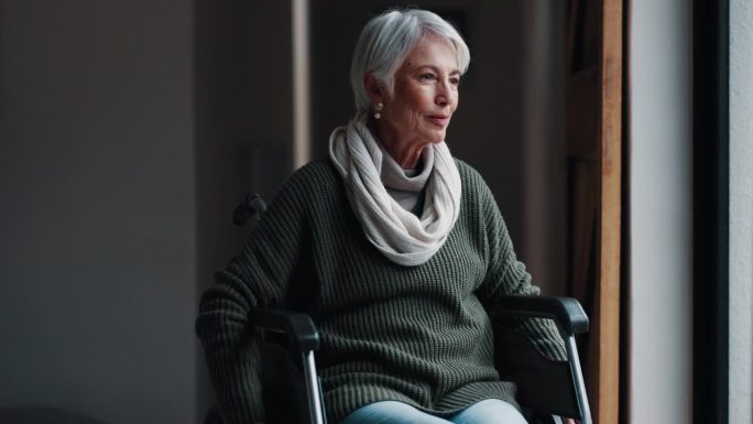 老年妇女坐在轮椅上，在养老院望向窗外，寻找希望、梦想或信念。孤独的老年女性或残疾人在疑惑中思考，在内