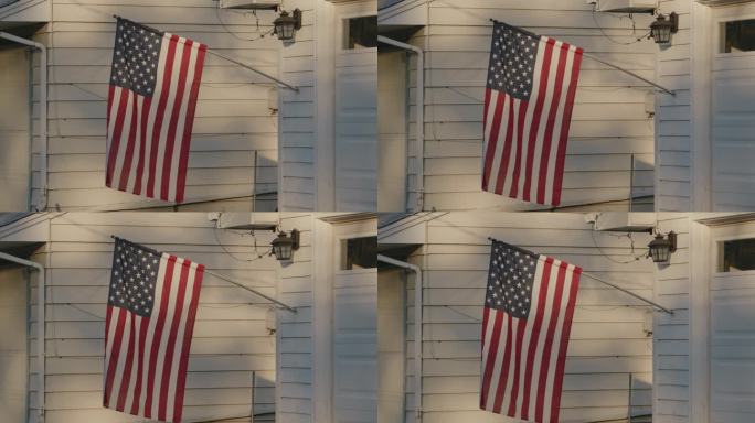 一面美国国旗在农舍的门廊上飘扬
