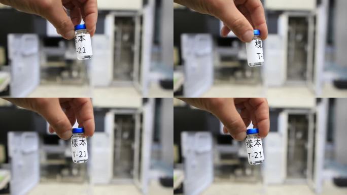 在分析化学实验室里，一名男子拿着一个小瓶，里面装着用中文写着“样品”的液体