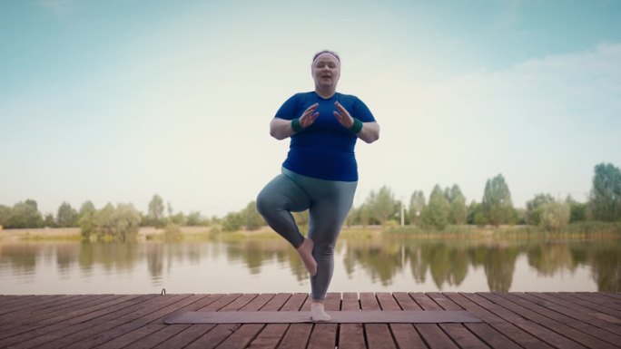 搞笑的大块头女人在公园瑜伽锻炼中失去平衡，滑稽的训练