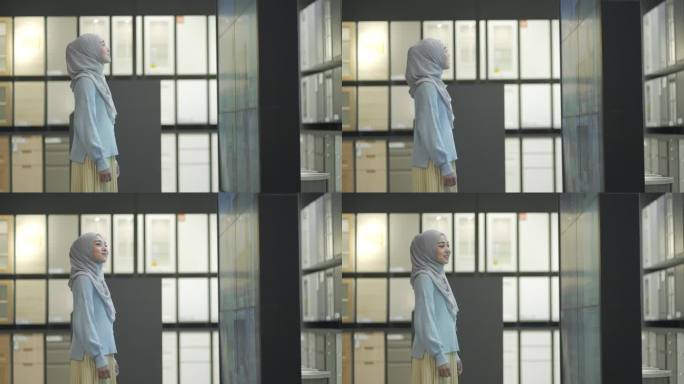 年轻的穆斯林妇女在看液晶电视墙