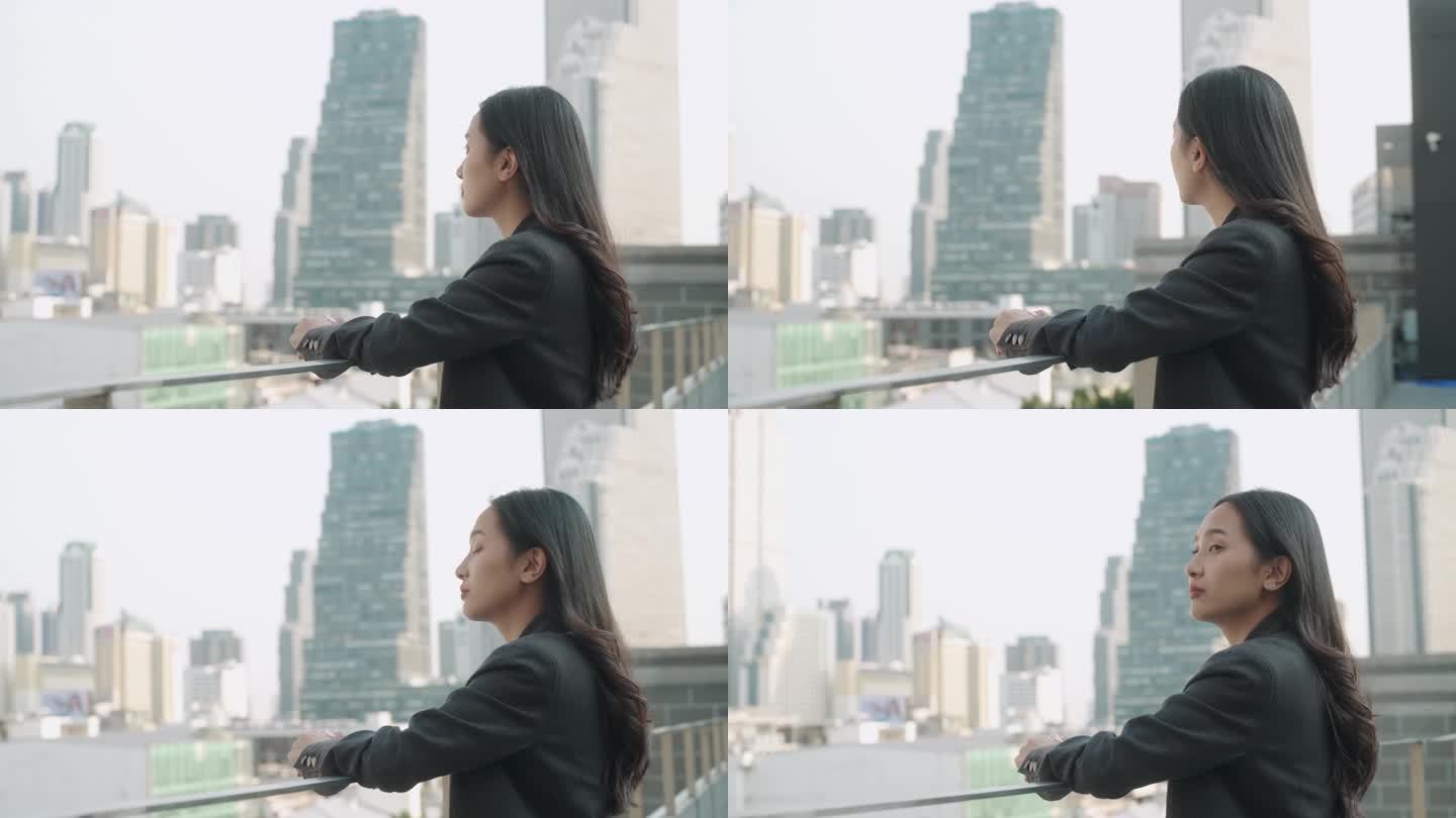 亚洲女人在屋顶上看城市风景