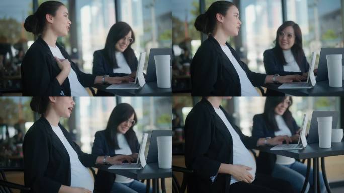 快乐的孕妇在办公室外工作时一边聊天一边揉肚子。
