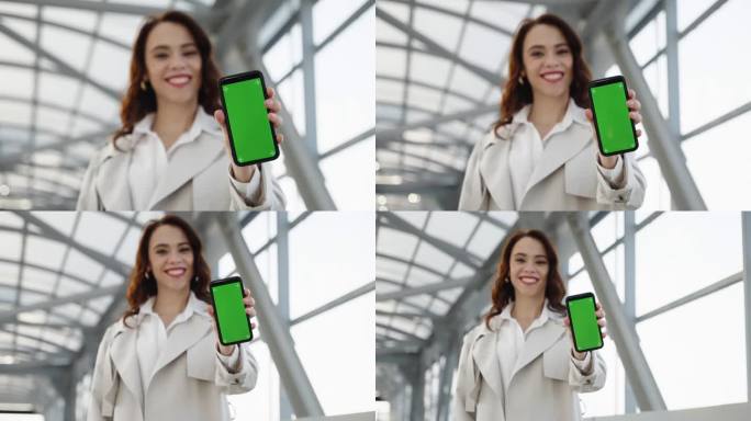 美丽的女孩展示了一款带有绿色屏幕的手机，可以插入内容。色度键在一个穿着浅色衣服的女孩手中。