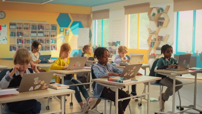 建立镜头:多民族儿童在小学课堂上使用笔记本电脑的课堂。聪明的男孩和女孩接受现代教育和技术实践