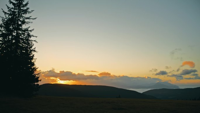 日出时，徒步旅行者在宁静的山野上的剪影