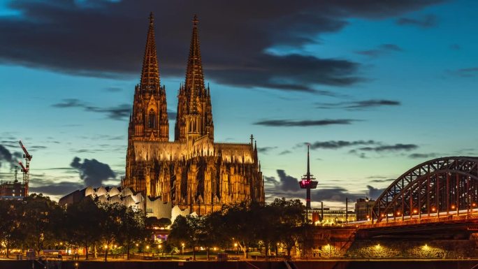 在科隆，德国，欧洲，旅游和旅游目的地的莱茵河上的科隆大教堂与霍亨索伦桥的4K镜头日夜延时