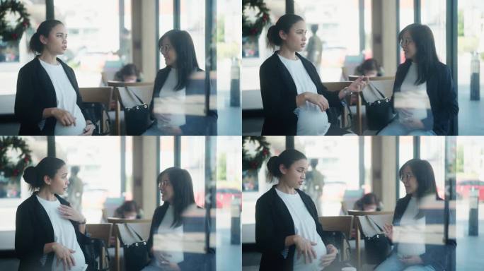 两个怀孕的女商人在一家现代化的咖啡店里讨论一个项目。