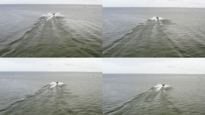 水上摩托艇掠过海面，在它的尾迹上留下泡沫的痕迹