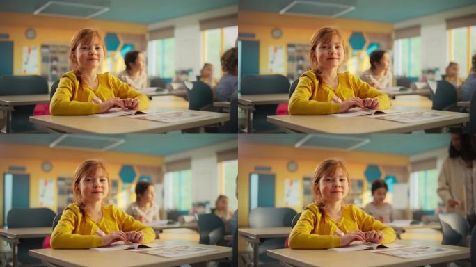 一个可爱的红发女孩坐在课桌后面的肖像。小学生微笑着看着镜头。在现代小学接受教育的孩子