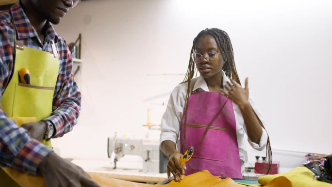 在皮革行业工作的黑人年轻男女裁缝