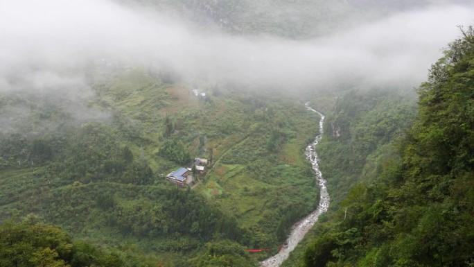 宁静的村庄在鲁远坪峡谷在雨天，多云和毛毛雨的日子，小溪在山谷中流淌。高角度观看4k慢动作镜头。