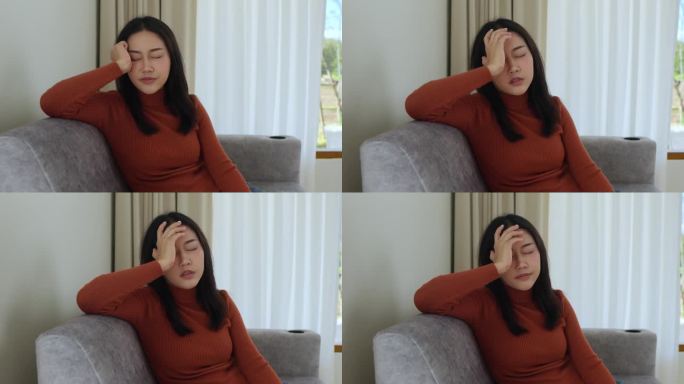 亚洲女性独自坐在家里的沙发上，思考个人问题，与男友分手或离婚，需要心理帮助，感到孤独和沮丧