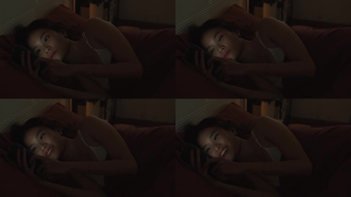 女人睡前在床上玩智能手机