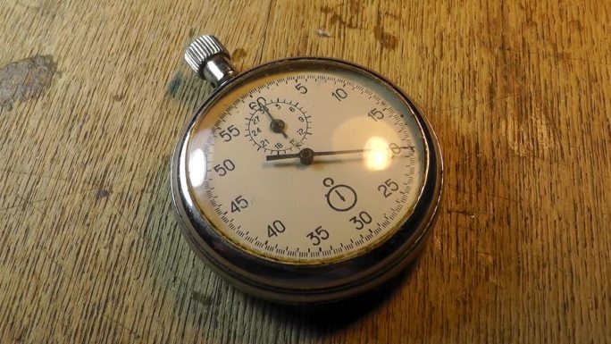 旧的秒表钟放在木桌上