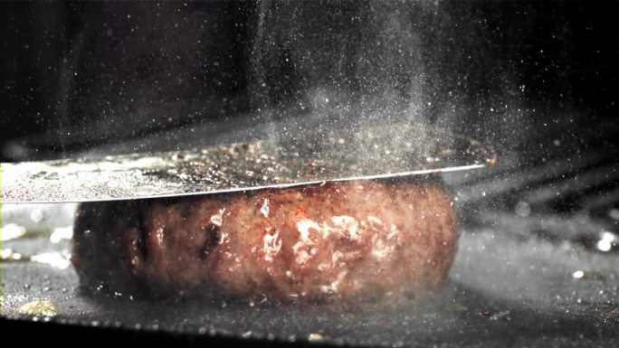 用天然肉类制成的汉堡在煎锅里煎。用高速摄像机拍摄，每秒1000帧。