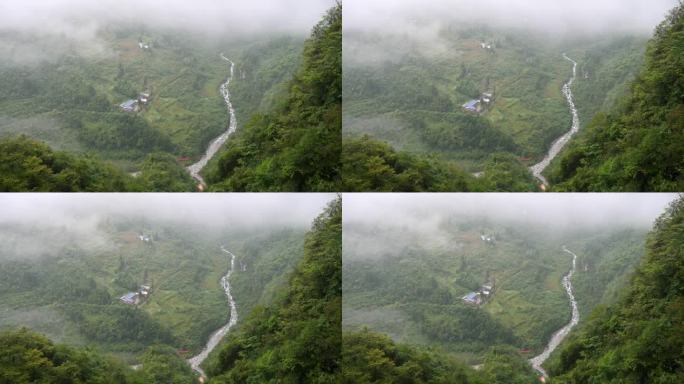 宁静的村庄在鲁远坪峡谷在雨天，多云和毛毛雨的日子，小溪在山谷中流淌。高角度观看4k慢动作镜头。