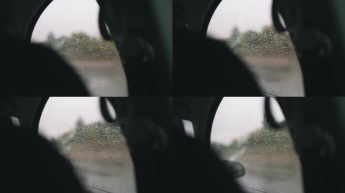 春雨中驾车行驶在湿滑的道路上，透过布满雨滴的车窗望去，在雨中驾车，慢动作的电影镜头