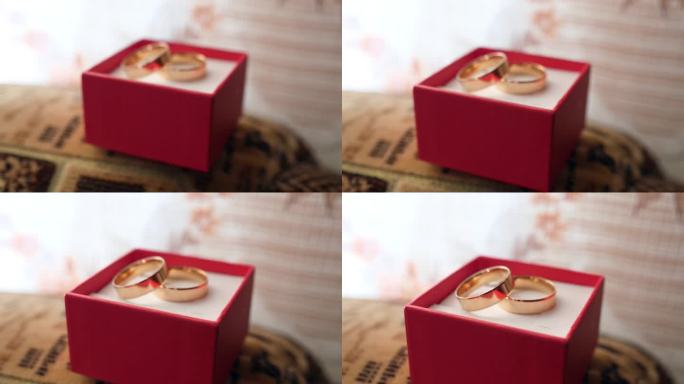红盒子里的金结婚戒指。婚礼仪式。慢动作