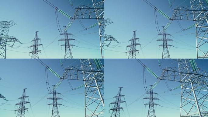 电压塔、输电线路、电力塔在阳光明媚的天空背景下。可再生绿色能源，清洁生态环境。替身。