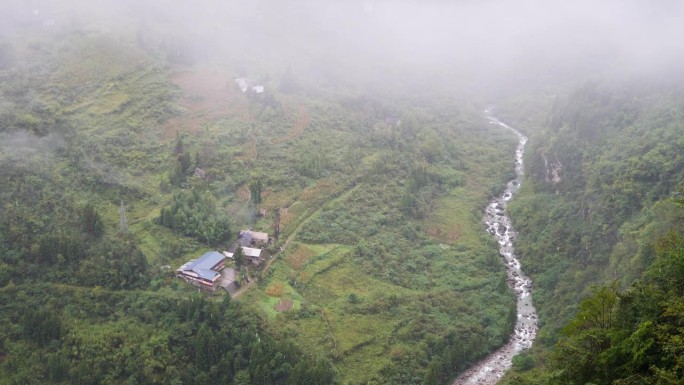 宁静的村庄在鲁远坪峡谷在雨天，多云和毛毛雨的日子，小溪在山谷中流淌。高角度观看4k慢动作镜头。