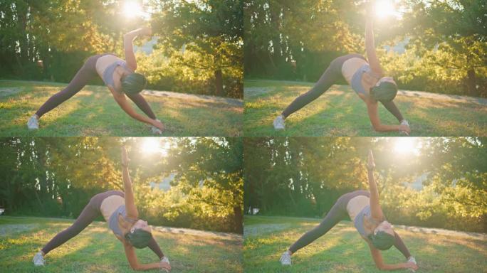 在阳光公园做弯管运动的女人。柔韧的运动员女士向后伸展