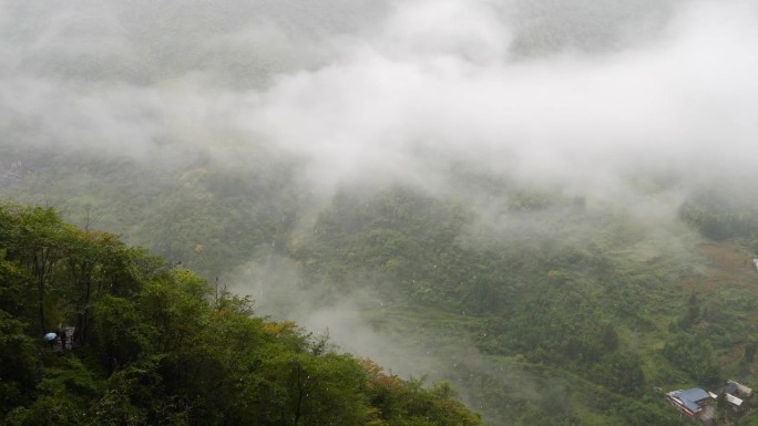 宁静的村庄在鲁远坪峡谷在雨天，多云和毛毛雨的日子，小溪在山谷中流淌。高角度观看4k慢动作镜头。