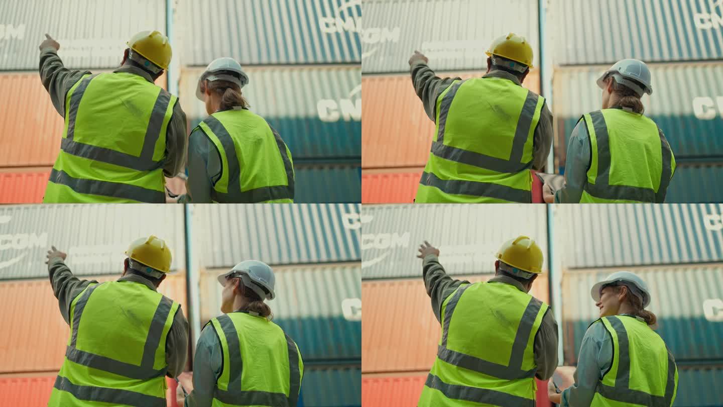 两名身穿安全制服的工业工程师在仓库一起工作的后视图。产业工人检查从工厂到货船的集装箱箱。航运、物流经