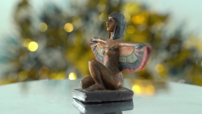 梦幻的特写镜头，克利奥帕特拉雕像与宽阔的鸟翅膀，闪亮的金色景深，埃及历史统治者，女神的古董艺术品，旋