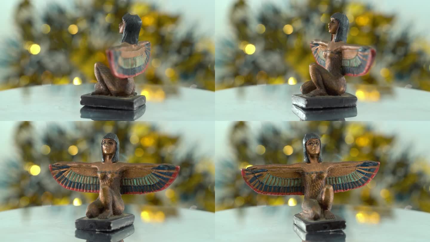 梦幻的特写镜头，克利奥帕特拉雕像与宽阔的鸟翅膀，闪亮的金色景深，埃及历史统治者，女神的古董艺术品，旋