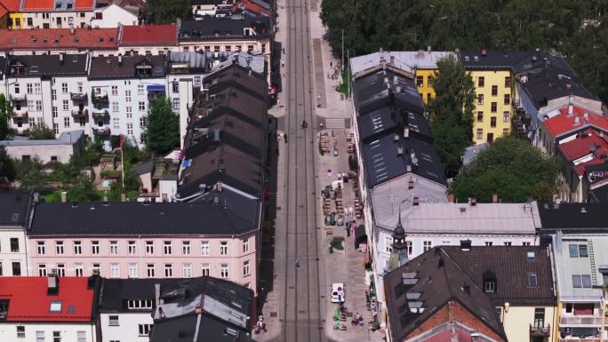 前锋在市区街道上空飞行。有电车轨道的行人大道的高角度视图。挪威奥斯陆