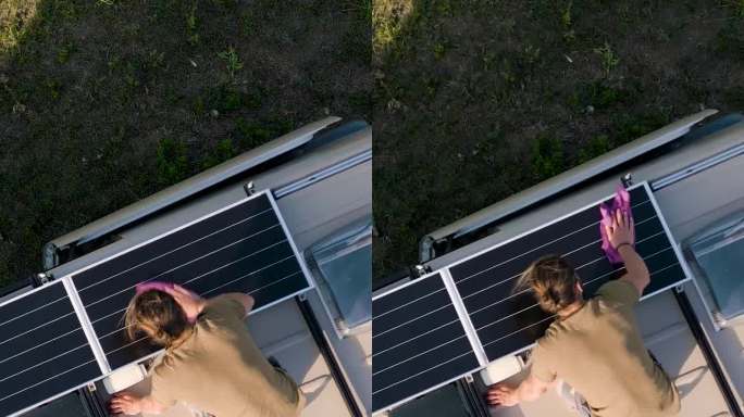 鸟瞰图:一名男子正在清洁露营车车顶上的太阳能电池板