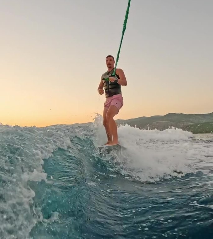 SLO MO冒险的男性冲浪者滑翔优雅，在迷人的日落在海上骑浪