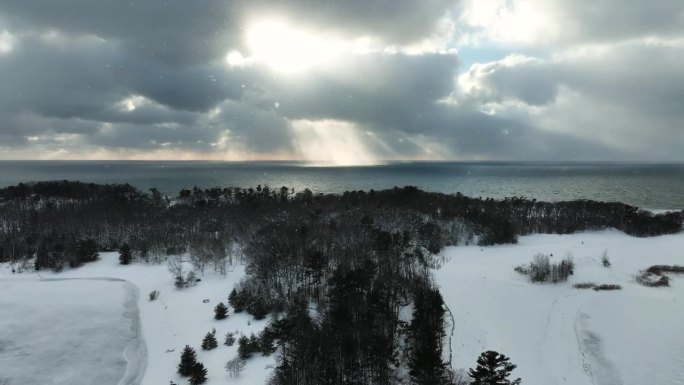 Sunsetting behind cloud cover as a flurry rolls in