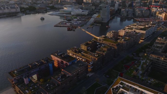 日落时分，索伦加区的现代公寓楼的高角度视图。向上倾斜，展现奥斯陆歌剧院的城市景观。挪威奥斯陆