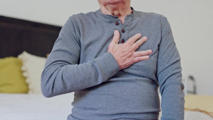 成熟时，男子与双手胸痛在卧室进行保健，在医院进行医疗和治疗的特写。老年人，心脏病发作，哮喘或心脏病急