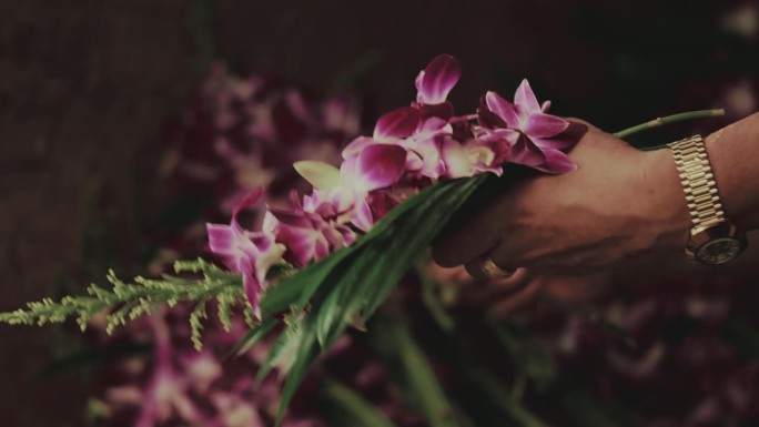 一个商人的手绑着紫色的兰花
