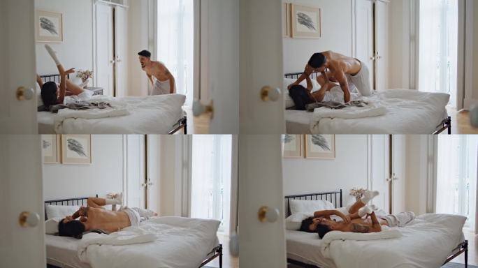 开心男友跳老婆躺床。无忧无虑的夫妇在卧室里玩耍