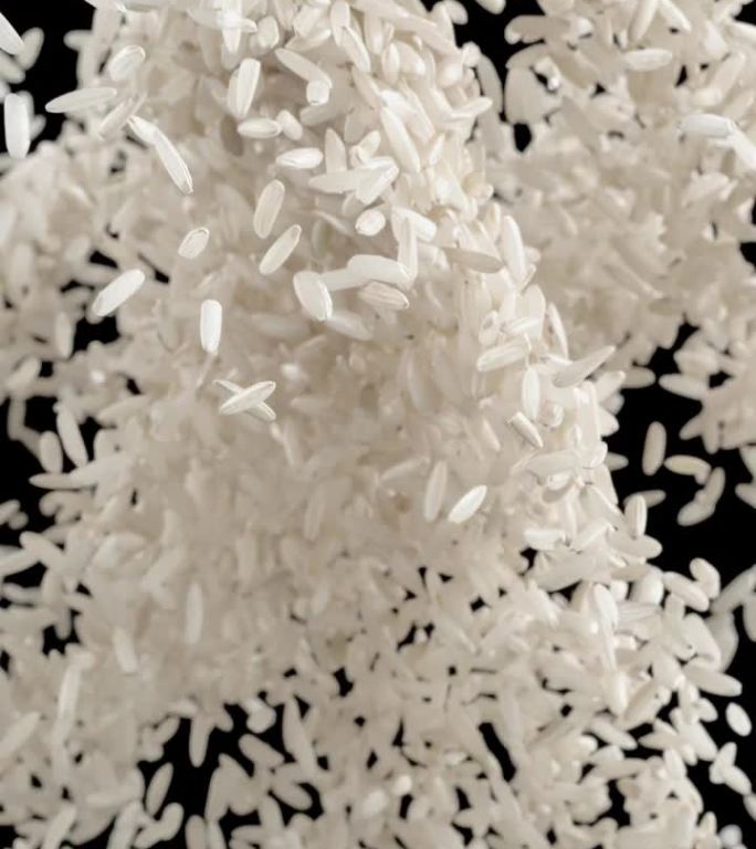 超慢动作纯煮熟的白米粒抛在空中，散落在黑色背景上