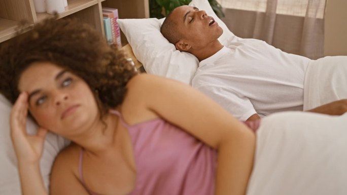 疲惫的漂亮夫妇捂着耳朵躺在床上，卧室里的鼾声让他们倍感压力